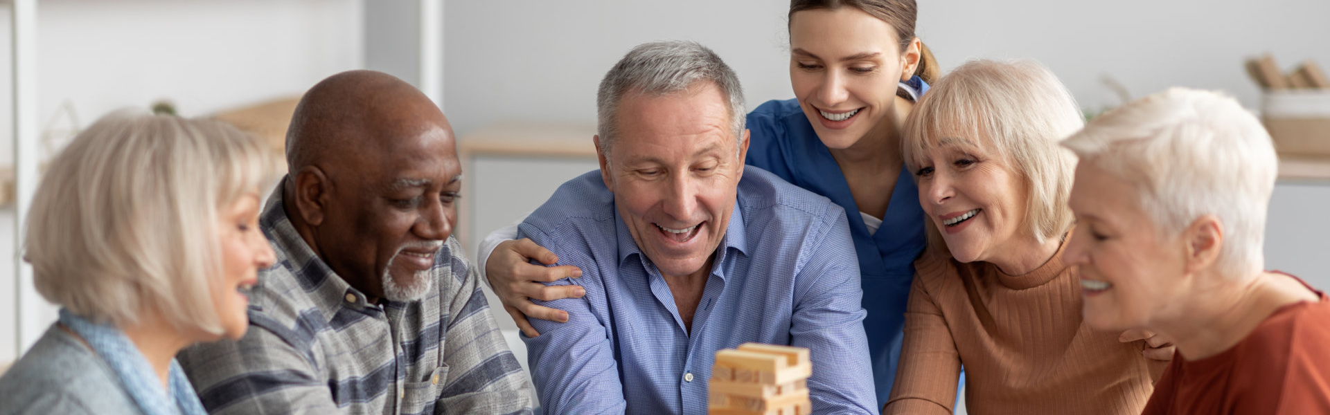 group of elderly talking while their caregiver is at the back