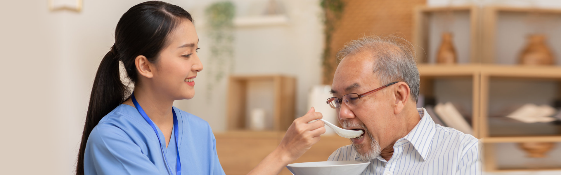 caregiver feeding the elderly man